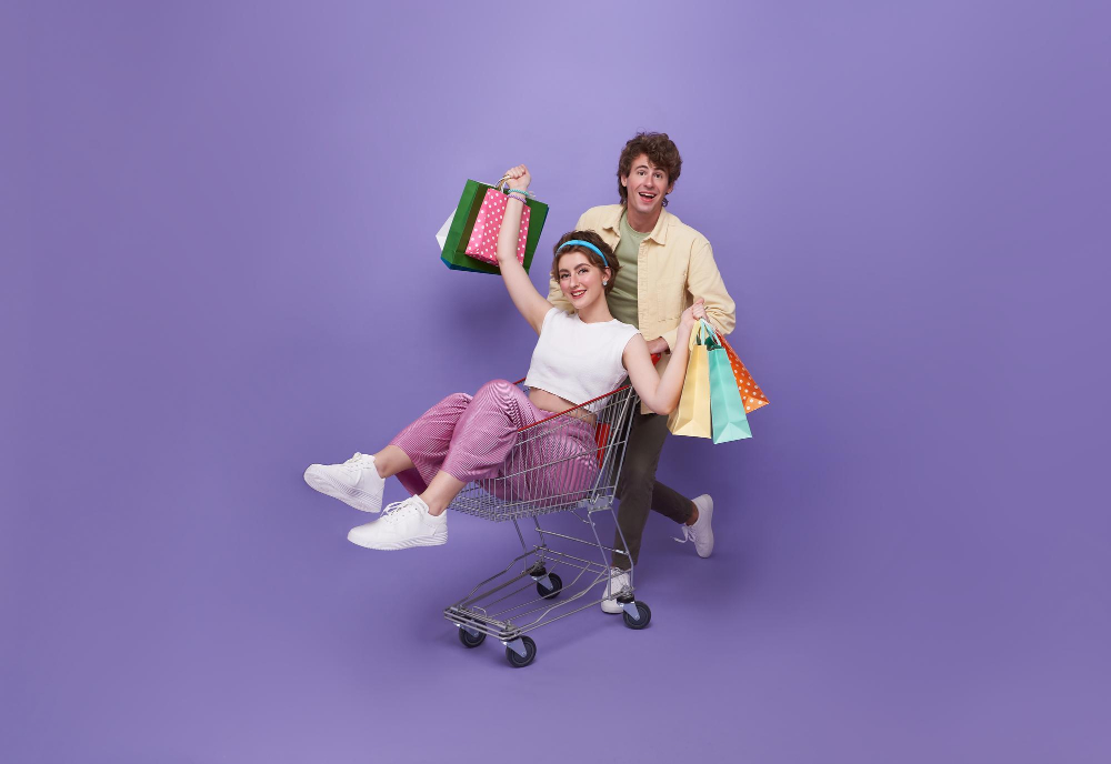 man pushing woman in shopping cart holding several bags man pushing woman in shopping cart holding several bags